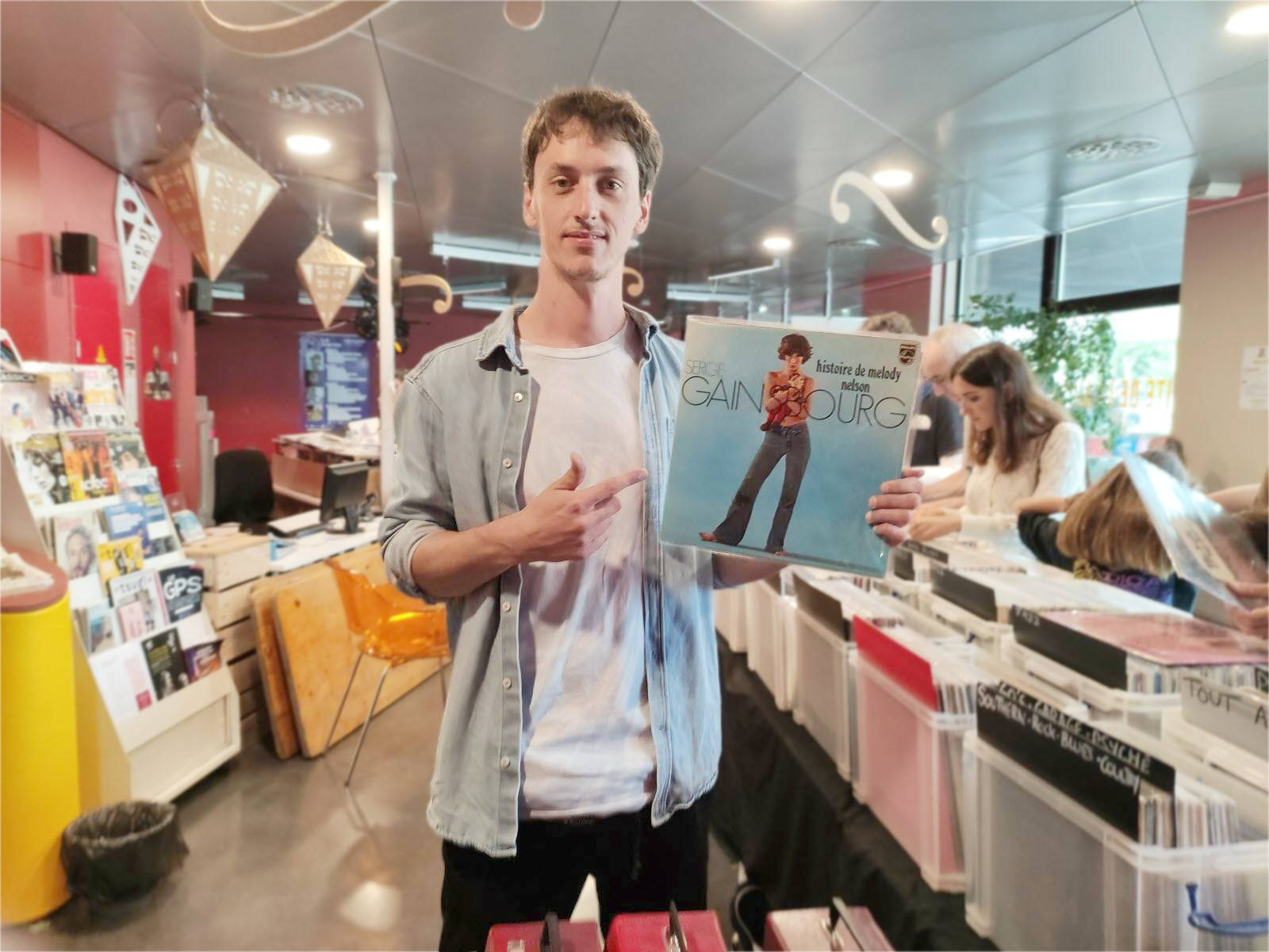 Tibo de face au milieu de ses bacs tenant l'un de ses produits en vente